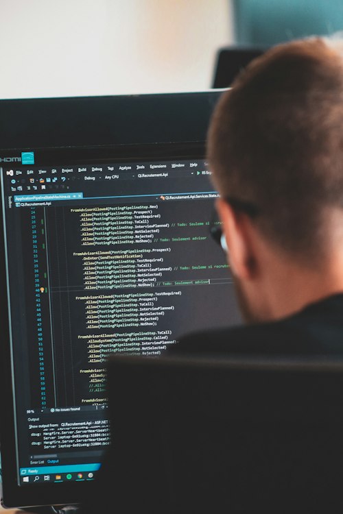 Écran de code vu par-dessus l'épaule d'un développeur